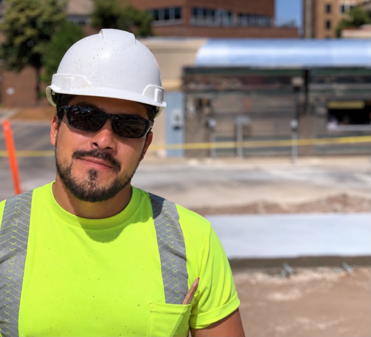 Arturo on a job site in a hard hat and hi-vis shirt