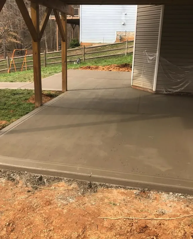 Covered concrete patio beneath a pergola