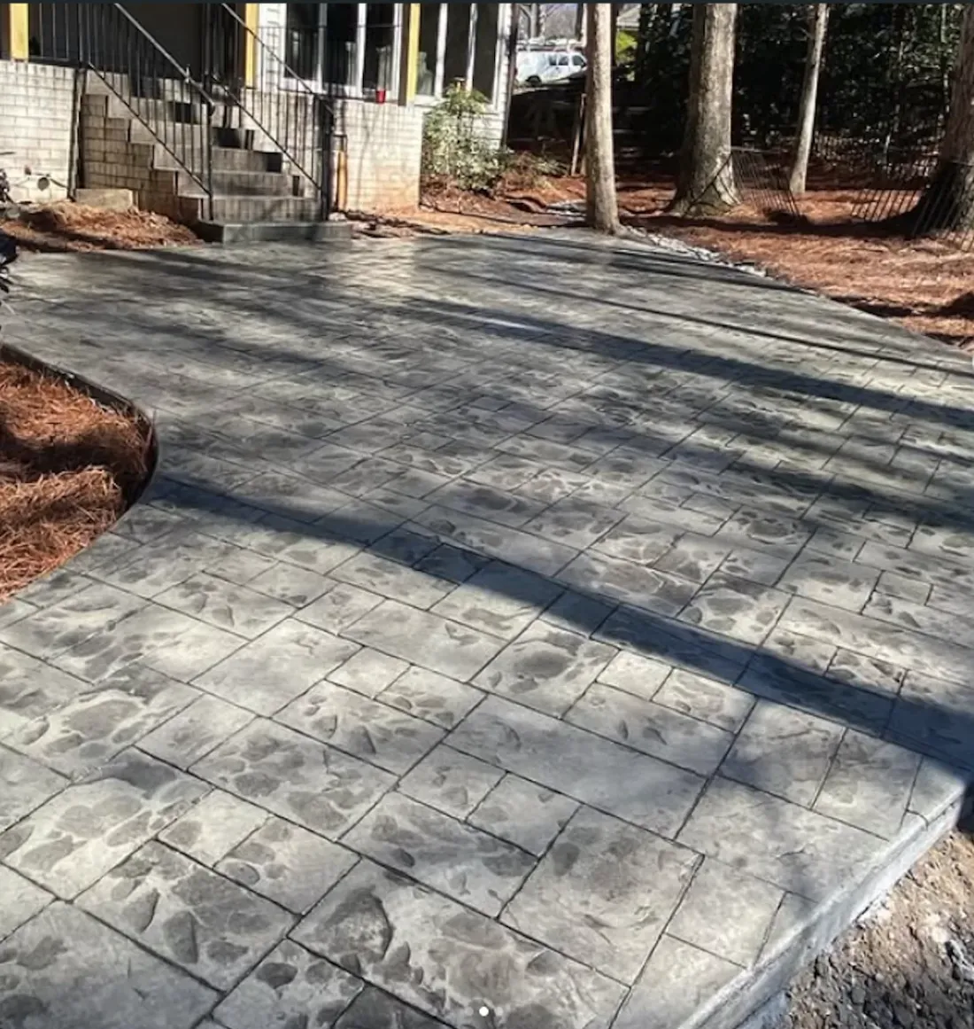 Gray stamped concrete patio behind a home